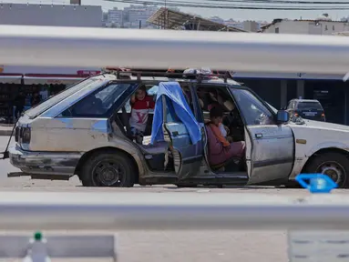 Keluarga pengungsi yang meninggalkan desa mereka di Lebanon Selatan berlindung di dalam mobil mereka di jalan di kota pelabuhan selatan Sidon, Rabu 10 Juni 2026. (AP Photo/Mohammed Zaatari)