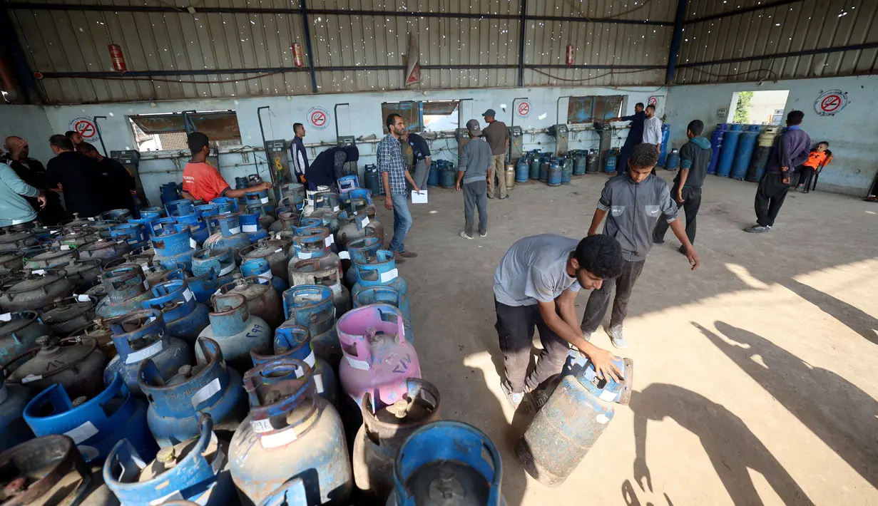 Blokade Israel juga menghalangi masuknya bantuan medis, serta pangan, yang memperburuk penderitaan lebih dari dua juta warga Gaza yang kini hidup dalam kelelahan ekstrem akibat genosida berkepanjangan. Tampak dalam foto, pekerja Palestina memuat tabung gas setelah diisi untuk pertama kalinya dalam setahun, di stasiun pengisian resmi di kamp pengungsi Nuseirat, di bagian tengah Jalur Gaza, pada 10 November 2025. (Eyad Baba/AFP)