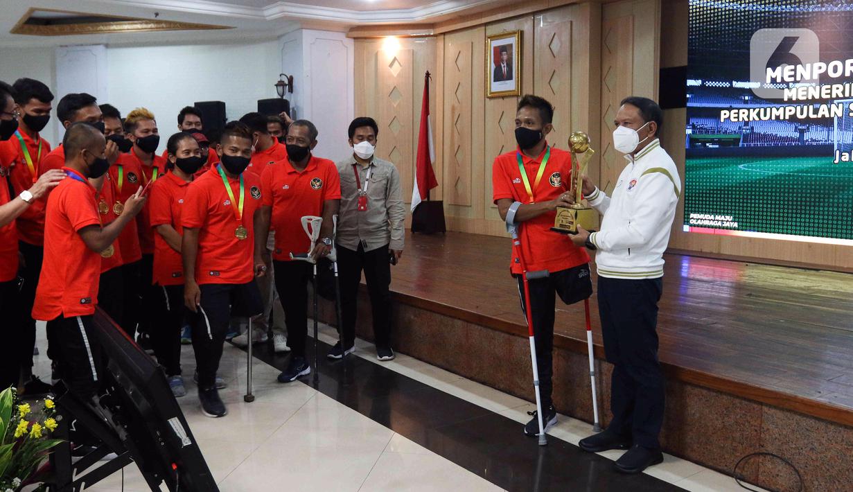 Menpora Zainudin Amali (kanan) saat menghadiri pertemuan dengan pemain Timnas Sepak Bola Amputasi Indonesia di Gedung Kemenpora, Jakarta, Kamis (17/3/2022). Timnas Sepak Bola Amputasi Indonesia baru saja memastikan diri lolos ke Piala Dunia Amputasi 2022 di Turki. (Liputan6.com/Herman Zakharia)