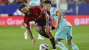 Gelandang Osasuna, Ruben Garcia dilanggar oleh gelandang Barcelona Gavi pada pekan keempat La Liga Spanyol di stadion Pamplona, Senin (4/9/2023). (AP Photo/Alvaro Barrientos)