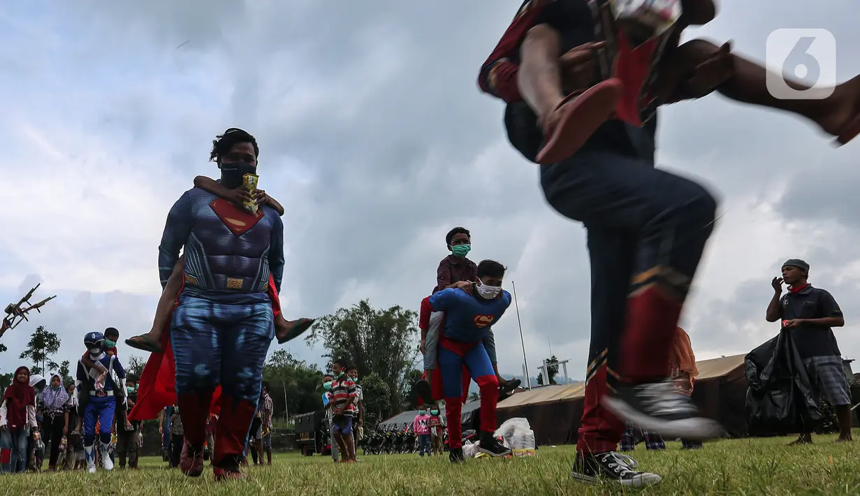 Relawan berkostum superhero bermain dengan anak-anak di Tempat Pengungsian Sementara Gunung Merapi, Desa Klakah, Selo, Boyolali, Jawa Tengah, Sabtu (21/11/2020). Kegiatan bermain ini untuk mengisi waktu anak-anak sehingga dapat menjaga kondisi anak tetap ceria dan sehat. (Liputan6.com/Johan Tallo)