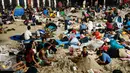 Dua orang anak bermain pasir usai menyaksikan atraksi kembang api pergantian tahun di Pantai Lagoon, Ancol, Jakarta, Minggu (1/1). (Liputan6.com/Gempur M. Surya)