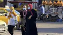 Perempuan Tunisa mengenakan masker untuk melindungi diri dari virus Corona terlihat di sebuah pasar saat kasus baru infeksi melonjak, di kota Gabes, Rabu (27/8/2020). Tunisia pada 25 Agustus 2020 melaporkan peningkatan tertinggi kasus baru Covid-19 dibandingkan minggu sebelumnya. (FETHI BELAID/AFP)