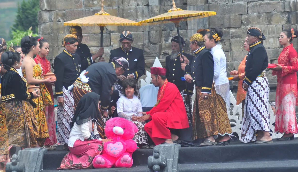 Seorang pemangku adat memotong rambut gimbal seorang anak saat ritual ruwatan potong rambut gimbal di komplek candi Arjuna dataran tinggi Dieng Desa Dieng Kulon, Jateng, Minggu (3/7).Prosesi adat ini akan memotong 11 anak berambut gimbal.(Gholib)