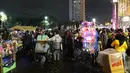 Pedagang menjual terompet, balon dan makanan pada malam pergantian tahun di kawasan Bundaran HI, Jakarta, Senin (31/12). Pergantian tahun dimanfaatkan pedagang untuk mencari keuntungan dengan berjualan pernak pernik tahun baru.(Liputan6.com/Angga Yuniar)