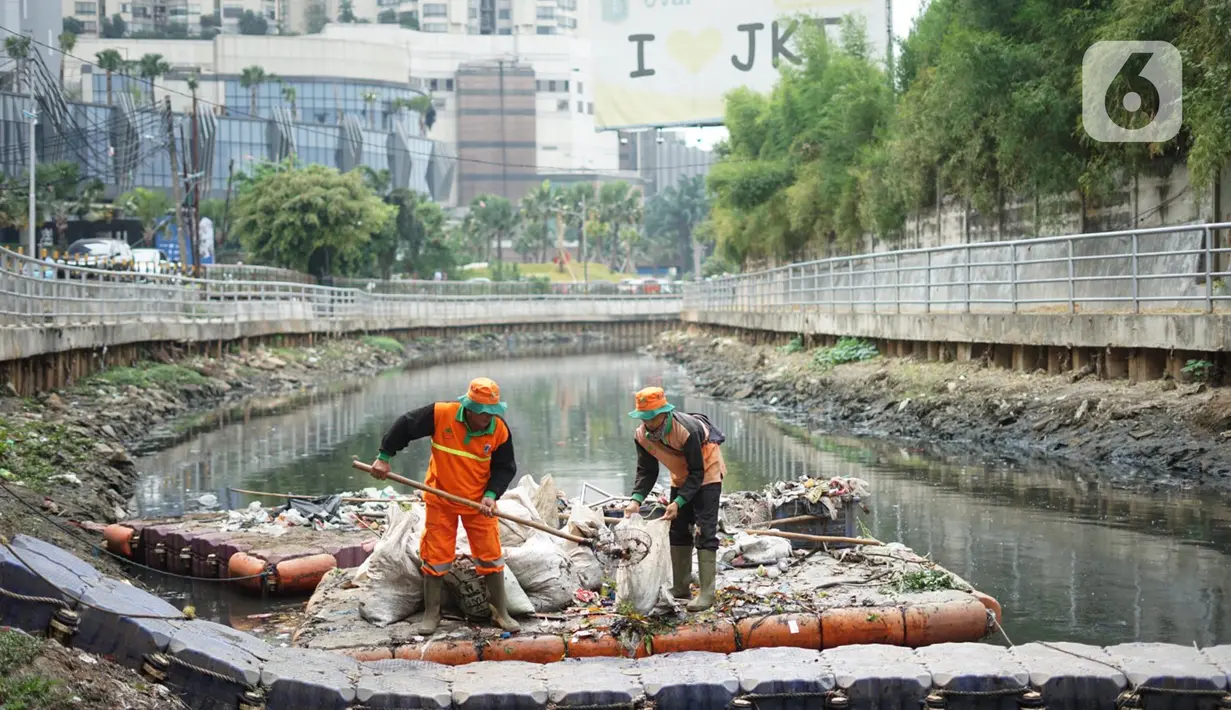 Petugas membersihkan sampah di sepanjang Kali Taman Anggrek, Jakarta, Rabu (8/7/2020). Banyaknya limbah menyebabkan Kali Taman Anggrek menjadi berwarna hitam dan berbau tidak sedap meskipun dibersihkan setiap hari. (Liputan6.com/Immanuel Antonius)