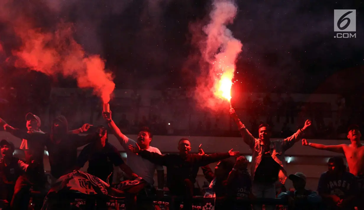 Suporter PSIS menyalakan suar saat merayakan kemenangan timnya melawan Martapura FC di Final tempat ketiga Liga 2 Indonesia di Stadion GBLA, Bandung, Selasa (28/11). PSIS unggul 6-4 dan lolos ke Liga 1 Indonesia. (Liputan6.com/Helmi Fithriansyah)