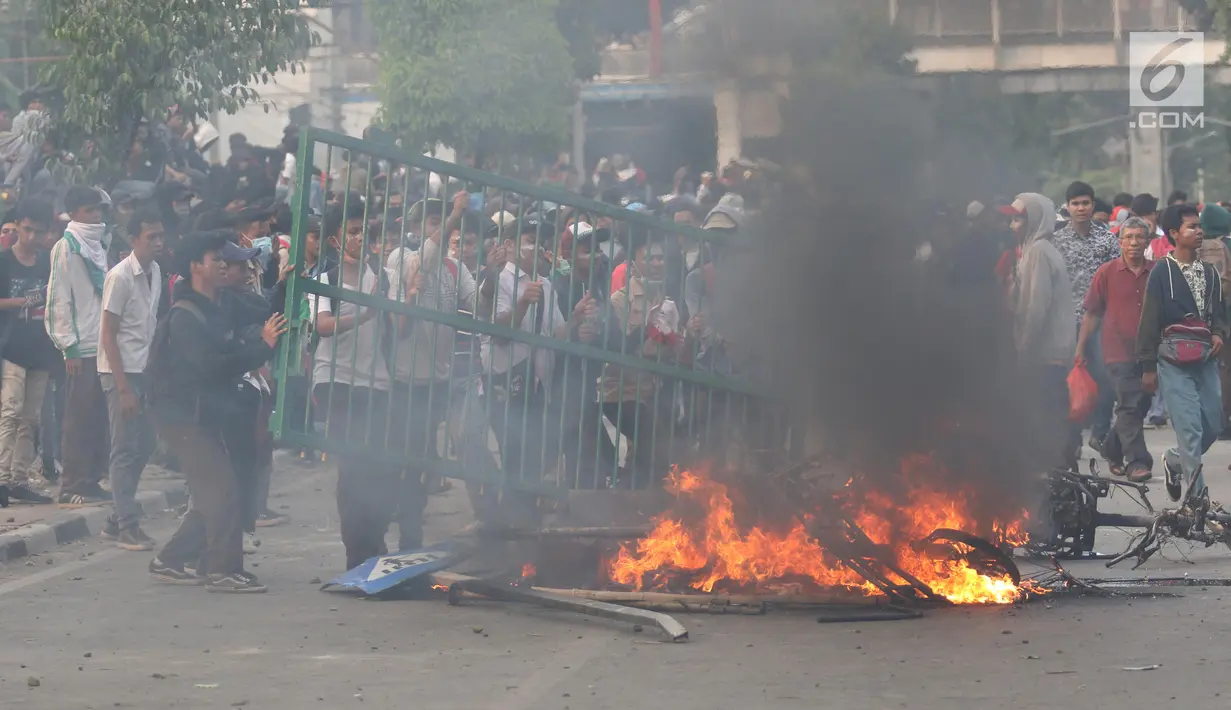 Pelajar membakar pagar saat berdemonstrasi di belakang Gedung DPR, Palmerah, Jakarta, Rabu (25/9/2019). Polisi menggelar sweeping di sejumlah titik untuk menjaring pelajar yang terlibat dalam demonstrasi rusuh di Gedung DPR. (Liputan6.com/Angga Yuniar)