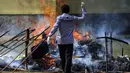 Seorang polisi membakar tumpukan ganja sitaan saat upacara di Polda Aceh, Banda Aceh, Aceh, Rabu (23/9/2020). Sebanyak 372,6 kilogram ganja dan 80,2 kilogram sabu serta 27.400 pil ekstasi hasil sitaan polisi dimusnahkan dalam acara tersebut. (CHAIDEER MAHYUDDIN/AFP)