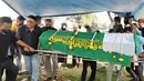 Tiba di pemakaman, jenazah Yulla Heri Burhania langsung dibawa ke pinggir liang lahat. Seorang ustaz kemudian langsung mengarahkan prosesi pemakaman. Dia meminta tiga orang keluarga untuk turun ke liang lahat, salah satunya adalah ayah Ressa Herlambang, Herman.(Muhammad Akrom Sukarya/Kapanlagi.com)