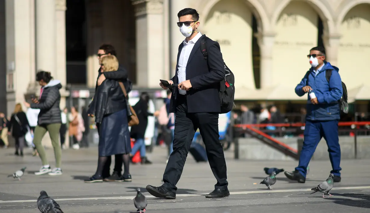 Warga memakai masker berjalan di Milan, Italia (24/2/2020). Kepala Departemen Perlindungan Sipil sekaligus Komisaris Luar Biasa untuk Darurat Coronavirus, Angelo Borrelli mengatakan enam orang meninggal dan 222 lainnya teruji positif infeksi COVID-19 di Italia. (Xinhua/Daniele Mascolo)