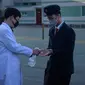 Petugas menyemprotkan cairan hand sanitizer kepada mahasiswa sebagai upaya mencegah penyebaran pandemi Covid-19 di Universitas Kedokteran Pyongyang, Rabu (22/4/2020). Korea Utara memberlakukan pembatasan ketat guna mengantisipasi penyebaran virus corona di negara tersebut. (KIM Won Jin/AFP)