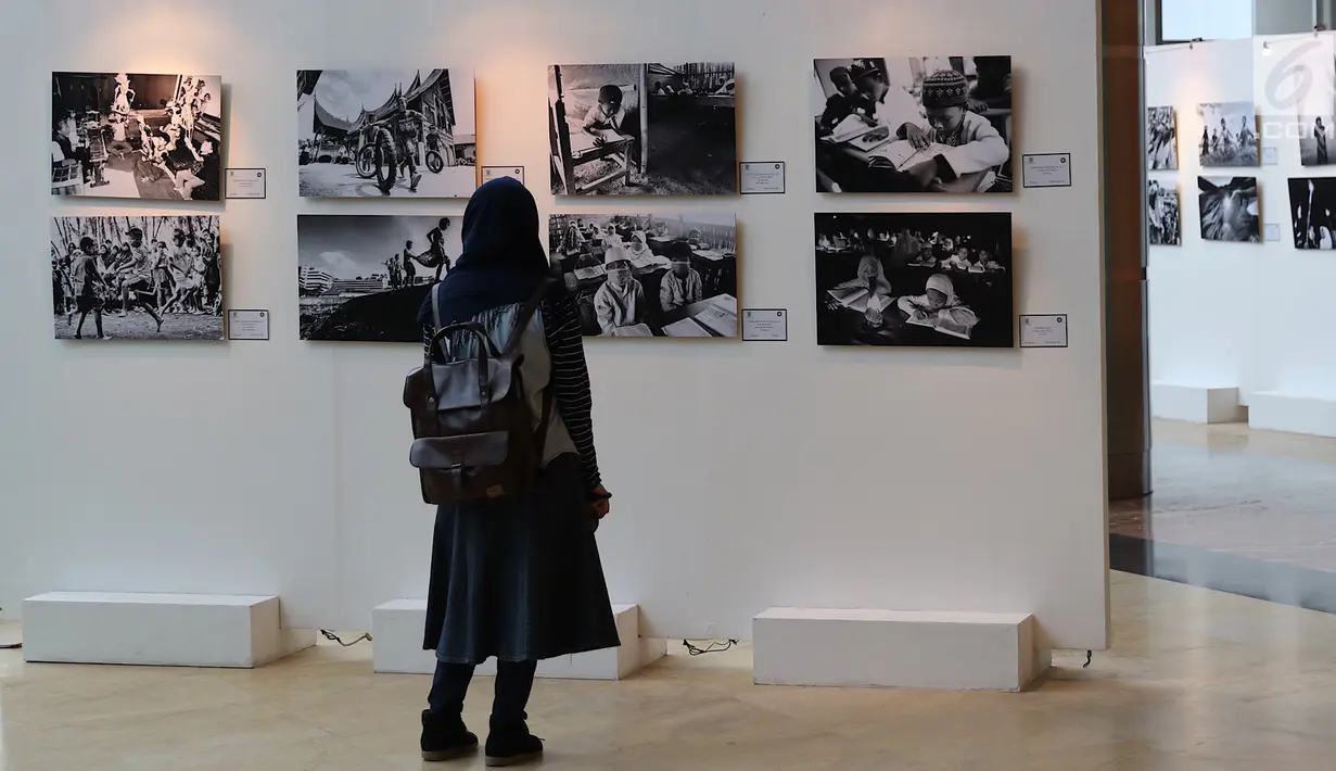 Seorang pengunjung melihat karya fotografi yang dipajang dalam pameran fotografi bertajuk “Semangat Anak Indonesia dalam Bingkai Hitam Putih” di TIM, Jakarta, Selasa (20/3). Pameran ini digelar hingga tanggal 22 Maret. (Liputan6.com/Immanuel Antonius)