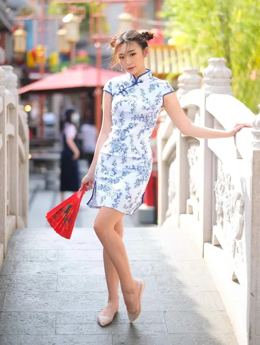 Livy Renata tampil bak LingLingh kenakan cheongsam mini dress putih dengan motif biru. Dipadukan dengan flatshoes dan tatanan rambut double bun [@livyrenata]