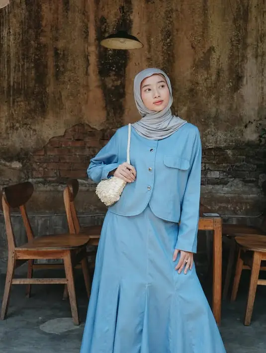 Tampil lebih feminim dengan blue on blue, mengenakan atasan kemeja berkantong dipadukan rok panjang pleated serta kerudung instan abu-abu. Membawa shoulder bag putih dan mengenakan heels strap silver. [@ansellmaputri]