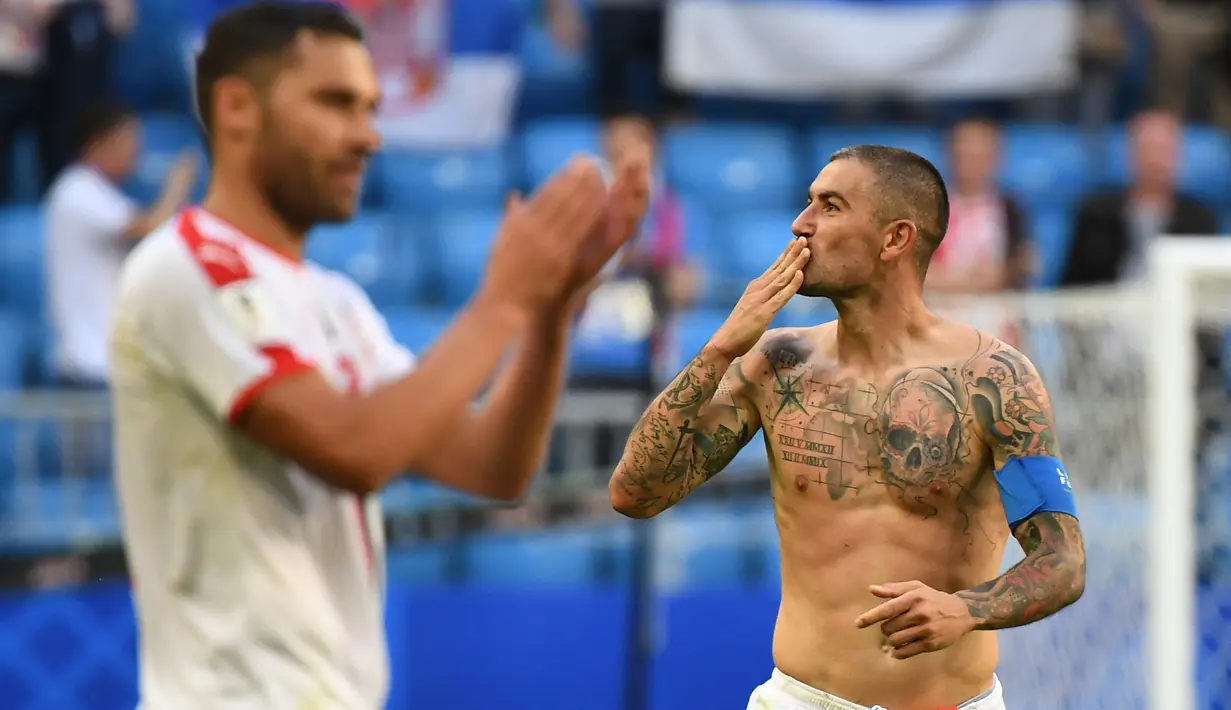 Bek Serbia, Aleksandar Kolarov dengan badan penuh tato merayakan kemenangan timnya di pertandingan sepak bola Grup E Piala Dunia 2018 Rusia di Samara, (17/6). Tato ikan koi dalam keyakinan Jepang melambangkan keberuntungan. (AFP PHOTO / Emmanuel Dunand)