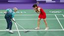 Seorang volunter sedang memberishkan keringan pebulu tangkis putri Thailand, Ratchanok Intanon saat pertandingan grup Olimpiade Paris 2024 melawan atlet Belgia, Lianne Tan di Porte de la Chapelle Arena, Paris, Prancis pada 30 Juli 2024. (AFP/Luis Tato)