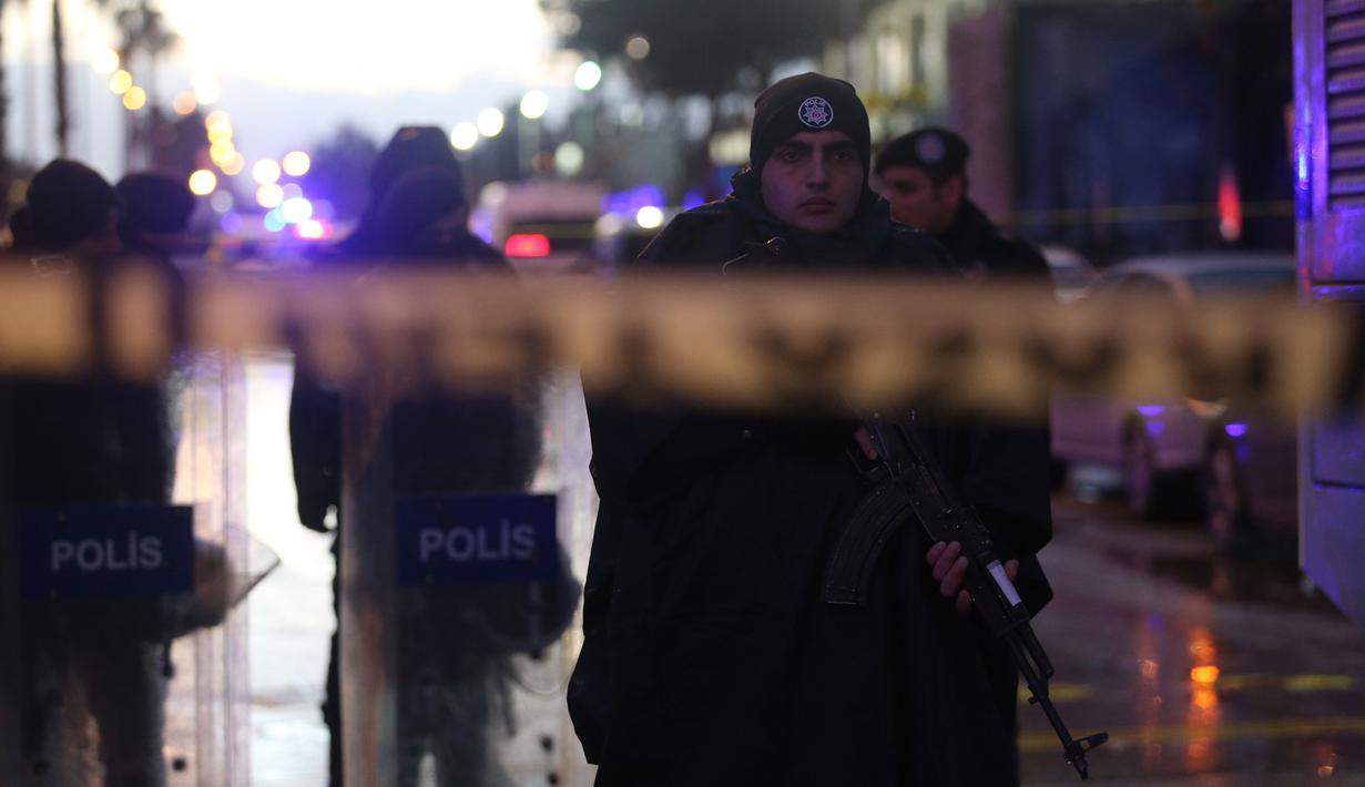 Polisi Turki mengamankan lokasi ledakan sebuah bom mobil yang terjadi di luar sebuah pengadilan di kota Izmir, wilayah barat Turki, Kamis (5/1). Dua penyerang dikabarkan tewas dalam baku tembak dengan pasukan keamanan. (AFP PHOTO/Emre TAZEGUL)