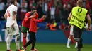 Penyerang Portugal, Cristiano Ronaldo berpose bersama seorang penyerbu lapangan muda selama pertandingan sepak bola Euro 2024 Grup F antara Turki dan Portugal di BVB Stadion, Dortmund pada 22 Juni 2024. (PATRICIA DE MELO MOREIRA/AFP)
