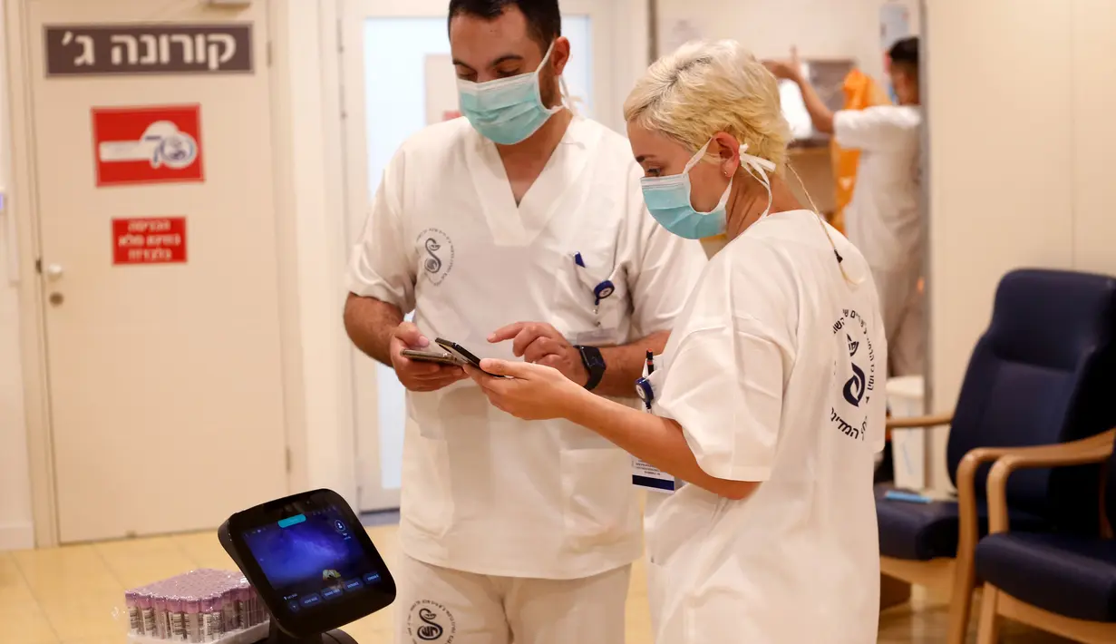 Petugas medis Israel menguji sebuah robot Temi di Sheba Medical Center dekat Tel Aviv, Israel, (12/5/2020). Robot Temi kini digunakan di sejumlah rumah sakit dan pusat medis guna membantu meminimalkan kontak antarmanusia di tengah merebaknya wabah Covid-19. (Xinhua/Gil Cohen Magen)
