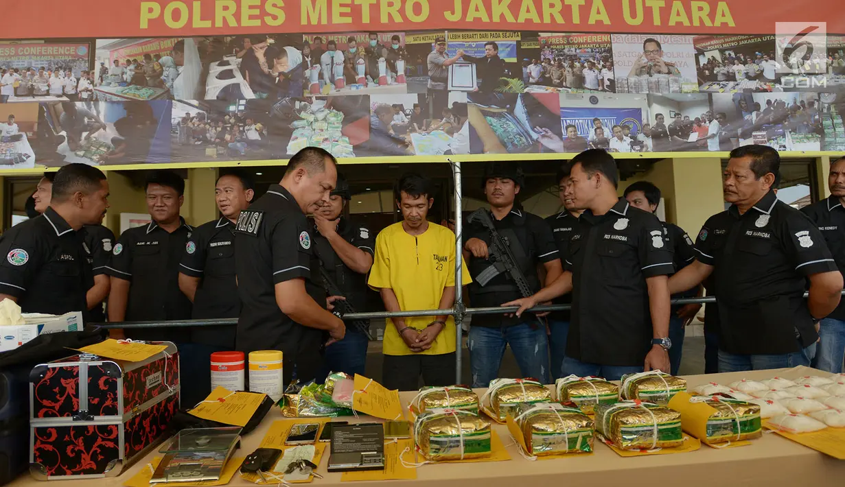 Petugas memperlihatkan tersangka dan barang bukti penyelundupan kasus narkotika jenis sabu di Mapolres Metro Jakarta Utara, Selasa (6/8/2019). Aparat kepolisian mengamankan seorang pengedar berinisial DA pada 27 Juli lalu saat menyelundupkan 10 kg sabu-sabu ke indekos. (merdeka.com/Imam Buhori)