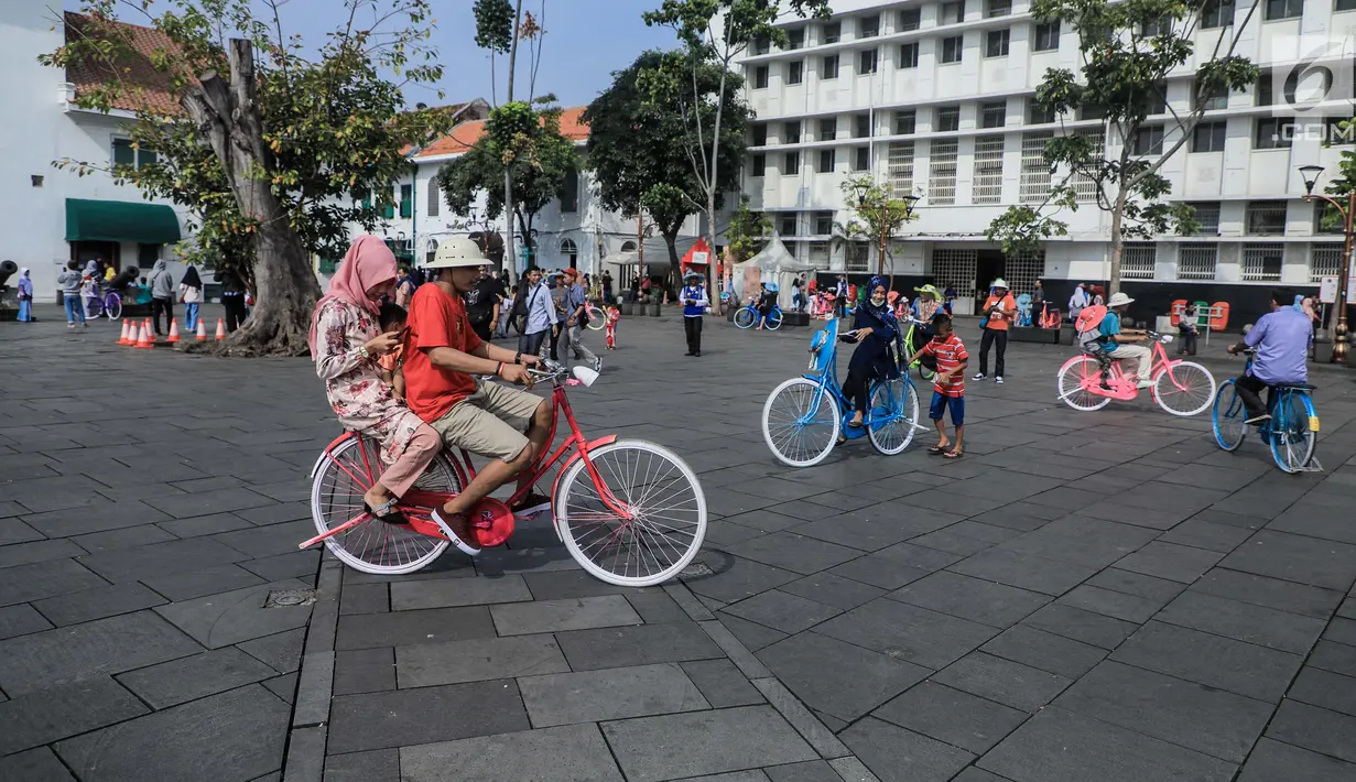 Pengunjung bersepeda mengelilingi kawasan Kota Tua, Jakarta, Sabtu (8/6/2019). Selama libur lebaran 2019, sejak 7 Juni kemarin hingga beberapa hari kedepan, jam berkunjung ke berbagai museum di kawasan wisata sejarah Kota Tua diperpanjang hingga pukul 20.00 WIB. (Liputan6.com/Faizal Fanani)
