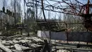 Sebuha kursi permainan di taman bermain yang sudah tidak digunakan lagi di kota Pripyat yang ditinggalkan penduduknya, dekat pembangkit tenaga nuklir, Ukraina, 28 Maret 2016. (REUTERS/Gleb Garanich)