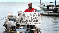 Seorang warga kampung nelayan berunjukrasa  Bulak Cumpat dan Nambangan menolak rencana reklamasi laut di kawasan Pantai Kenjeran Surabaya, Jumat (21/1). (Antara)