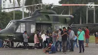 Warga mengerumuni helikopter TNI di kawasan Monumen Nasional, Jakarta, Jumat (19/4). Libur panjang perayaan Paskah 2019 dimanfaatkan warga untuk berwisata di kawasan Monumen Nasional. (Liputan6.com/Helmi Fithriansyah)