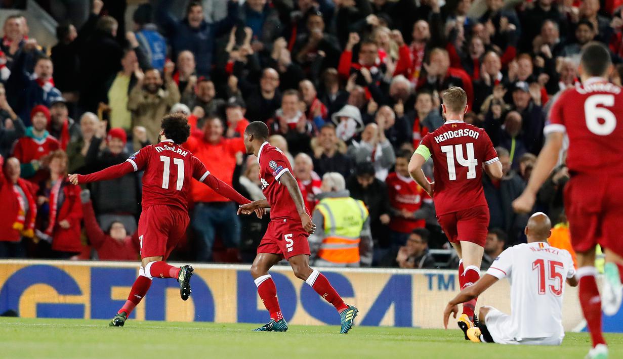 Gelandang Liverpool, Mohamed Salah bersama rekan setimnya berselebrasi setelah membobol gawang Sevilla dalam laga Grup E Liga Champions di Stadion Anfield, Rabu (13/9). Sevilla berhasil menahan imbang Liverpool dengan skor 2-2. (AP Photo/Frank Augstein)
