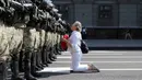 Seorang wanita berlutut di depan barisan polisi antihuru-hara saat mereka memblokir demonstrasi pendukung oposisi Belarusia di Minsk, Belarusia, Minggu (30/8/2020). Puluhan ribu demonstran berkumpul untuk menuntut agar Presiden Belarusia Alexander Lukashenko mengundurkan diri. (AP Photo)
