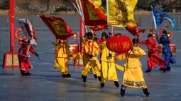 Seniman Tiongkok yang mengenakan kostum tradisional melakukan permainan es pada hari kedua perayaan Tahun Baru Imlek di danau beku di Taman Yuanmingyuan, Beijing, China, Senin (23/1/2023). Tahun Baru Imlek adalah hari libur tahunan terpenting di China. (AP Photo/Andy Wong)