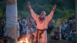 Seorang pria memimpin upacara ritual pagan kuno di dekat desa Glubokovo, Rusia (24/6). Ritual ini diyakini sebagai salah satu ritual tertua di dunia. (AFP Photo/Andrei Borodulin)