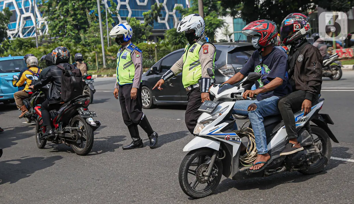 Petugas kepolisian lalu lintas memberhentikan pengendara motor saat Operasi Zebra Jaya 2020 di kawasan Cawang, Jakarta, Senin (26/10/2020). Operasi Zebra Jaya dilaksanakan pada 26 Oktober-8 November 2020 untuk menekan jumlah pelanggaran lalu lintas. (Liputan6.com/Faizal Fanani)