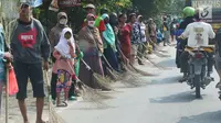 Sejumlah penyapu koin kali Sewo menunggu di sepanjang pinggir jalan, Subang, Jawa Barat, Sabtu (7/1). Mereka menunggu pengendara yang lewat melempar koin ke jalan. (Liputan6.com/Helmi Afandi)