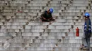 Pekerja membersihkan sisa besi penopang bangku penonton di Stadion GBK Jakarta, Selasa (18/10). Pengerjaan renovasi Stadion GBK bagian persiapan jelang Asian Games 2018 dan ditargetkan selesai Oktober 2017. (Liputan6.com/Helmi Fithriansyah)