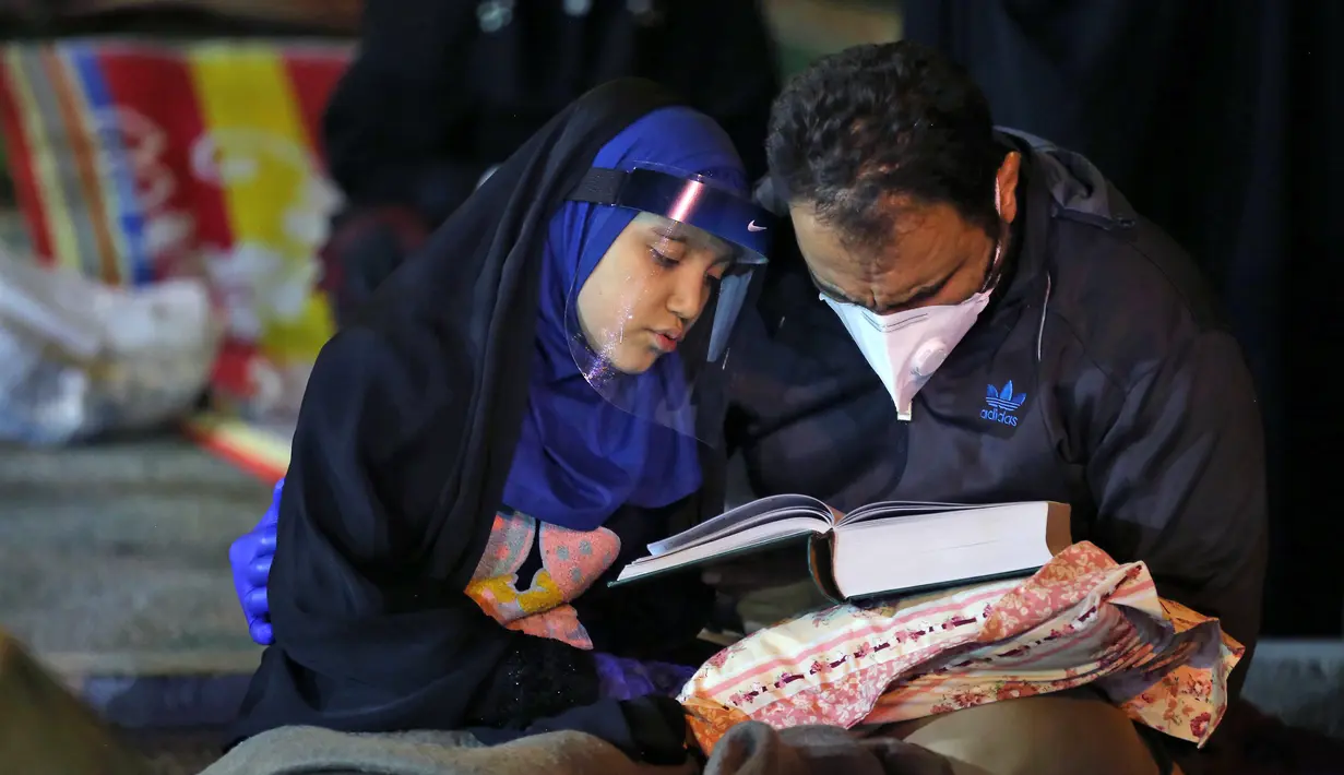 Warga Iran dengan mengenakan masker menghadiri acara kajian dan pengajian Lailatul Qadar, salah satu malam paling suci selama bulan Ramadan, di luar masjid di Teheran, Rabu (13/5/2020). Pemerintah Iran membuka kembali masjid-masjid untuk manyambut malam Lailatul Qadar. (ATTA KENARE/AFP)