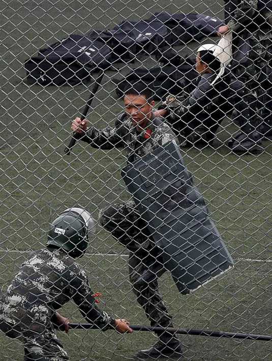 Dua polisi paramiliter China berlatih di stadiun olahraga di Shenzhen, kota di dekat perbatasan dengan Hong Kong, China (30/10/2019). China sangat mendukung langkah Hong Kong untuk melarang aktivis pro-demokrasi Joshua Wong dari pemilihan anggota dewan lokal. (AP Photo/Andy Wong)