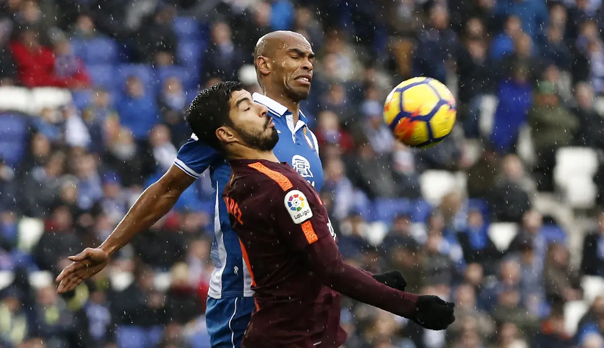 Duel pemian Barcelona, Luis Suarez (depan) pemain Espanyol, Naldo (kanan)  pada lanjutan La Liga santander di RCDE stadium, Cornella Llobregat, Spanyol, (4/2/2018). Espanyol dan Barcelona bermain imbang 1-1. (AFP/Pau Barrena)