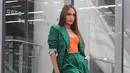 Untuk formal outfit, kombinasi set blazer hijau dengan bustier top warna oranye bikin penampilan terlihat lebih trendy! (Instagram/claurakiehl).