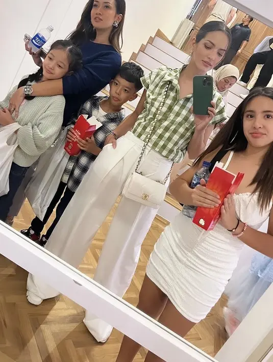 Mini dress tersebut dipadukan dengan sneakers putih warna serasi. Sementara itu, Nia tampil dengan kemeja motif kotak-kotak hijau dipadukan celana putih serasi dengan tasnya [@ramadhaniabakrie]