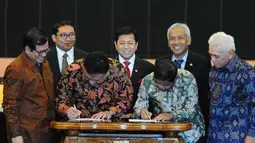 KIH diwakili Olly Dondokambey dan KMP diwakili Sekjen Partai Golkar Idrus Marham (kanan) saat menandatangi kesepakatan damai di Gedung DPR RI, Jakarta, Senin (17/11/2014). (Liputan6.com/Andrian M Tunay)