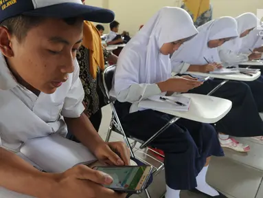 Pelajar menggunakan ponsel android mengikuti babak penyisihan lomba matematika dengan metode Gasing (Gampang Asyik & Menyenangkan) di SMKN 1 Leuwiliang, Bogor, Selasa (8/1). (Merdeka.com/Arie Sunaryo)