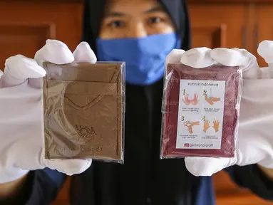 Pekerja menunjukkan pouch gemilang berisikan sabun cuci tangan berukuran kertas di Gemilang Craft Pamulang, Tangerang Selatan, Kamis (23/4/2020). Sebagian hasil penjualan produksi yang telah mencapai 2000 buah tersebut di donasikan dalam bentuk sembako dan baju hazmat. (Liputan6.com/Fery Pradolo)