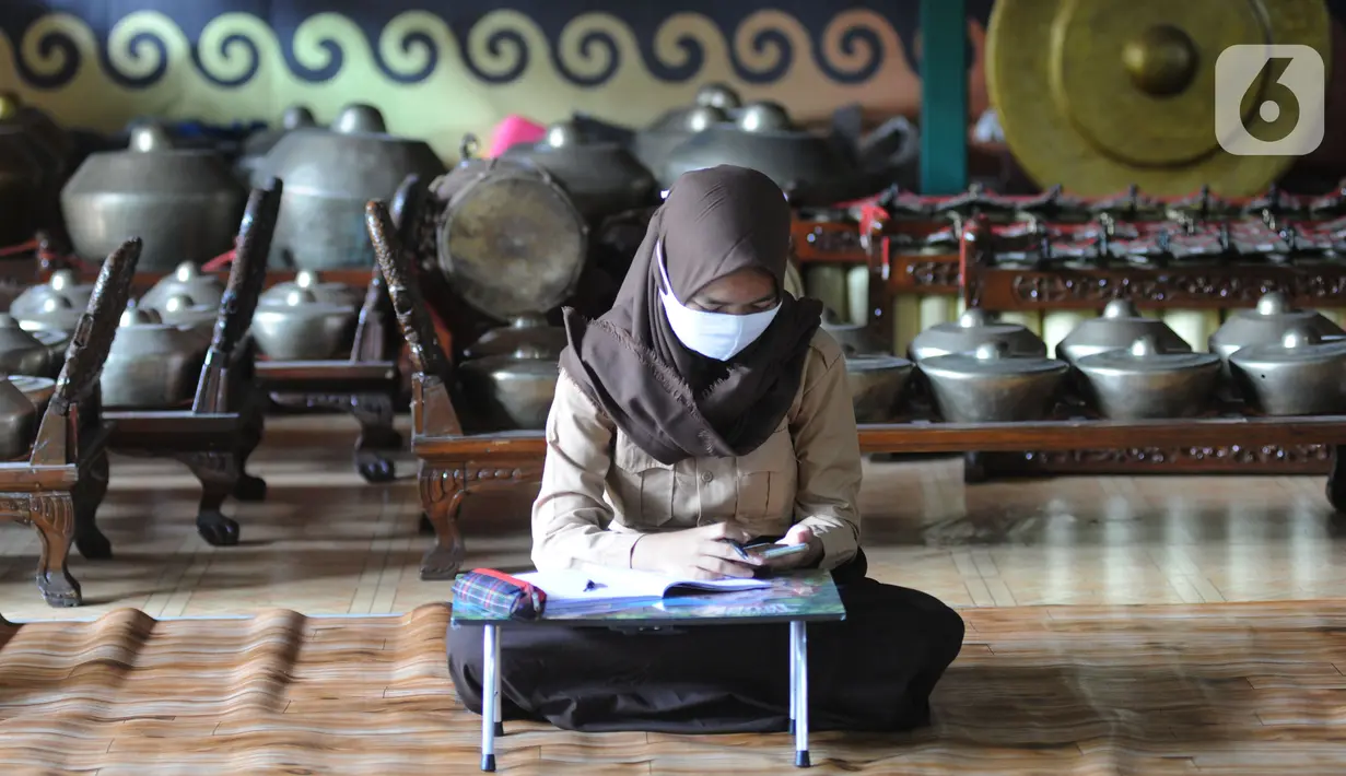 Siswa belajar secara daring menggunakan fasilitas wifi gratis di Perumahan Pondok Mulya I, Beji, Depok, Jawa Barat, Rabu (29/7/2020). Fasilitas tersebut disediakan oleh Sri Wiwoho untuk siswa sekitar perumahan. (merdeka.com/Arie Basuki)