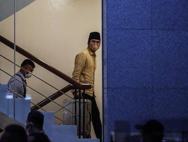 Bupati Bangkalan Abdul Latif Amin Imron membawa koper dan dikawal saat tiba di Gedung Komisi Pemberantasan Korupsi (KPK), Jakarta, Rabu (7/12/2022). KPK menangkap Bupati Bangkalan Abdul Latif Amin Imron sebagai tersangka kasus suap lelang jabatan di Pemerintahan Kabupaten Bangkalan, Jawa Timur. Total kekayaan yang dimiliki Abdul Latif sebanyak Rp 9,9 miliar. (Liputan6.com/Johan Tallo)