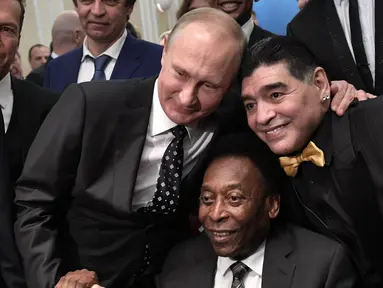Presiden Rusia Vladimir Putin berfoto bersama legenda sepak bola Brasil, Pele (tengah) dan legenda Argentina, Diego Maradona (kanan) saat menghadiri undian Piala Dunia 2018 di Moskow, Rusia (1/12). (AFP Photo/Sputnik/Alexey Nikolsky)