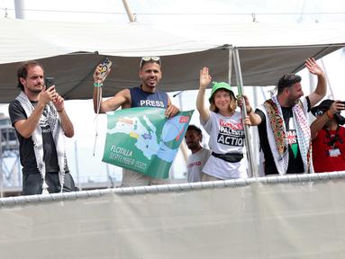 Aktivis iklim Swedia, Greta Thunberg (ketiga kiri) bersama sejumlah aktivis melambaikan tangan saat kapal mereka, yang merupakan bagian dari armada sipil yang bertujuan untuk memecahkan blokade Israel di Jalur Gaza, berangkat dari pelabuhan Barcelona pada 31 Agustus 2025. (Lluis GENE/AFP)