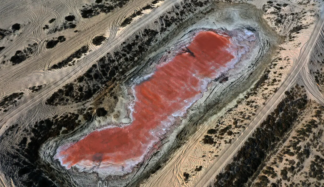 Penampakan danau merah muda di Ras Al Khaimah di Uni Emirat Arab (UEA) pada 26 Januari 2021. Terletak hanya sepelemparan batu dari garis pantai di pantai Al Rams di Kepulauan Saraya, airnya tampak merah muda cerah di atas pasir krem. (GIUSEPPE CACACE/AFP)