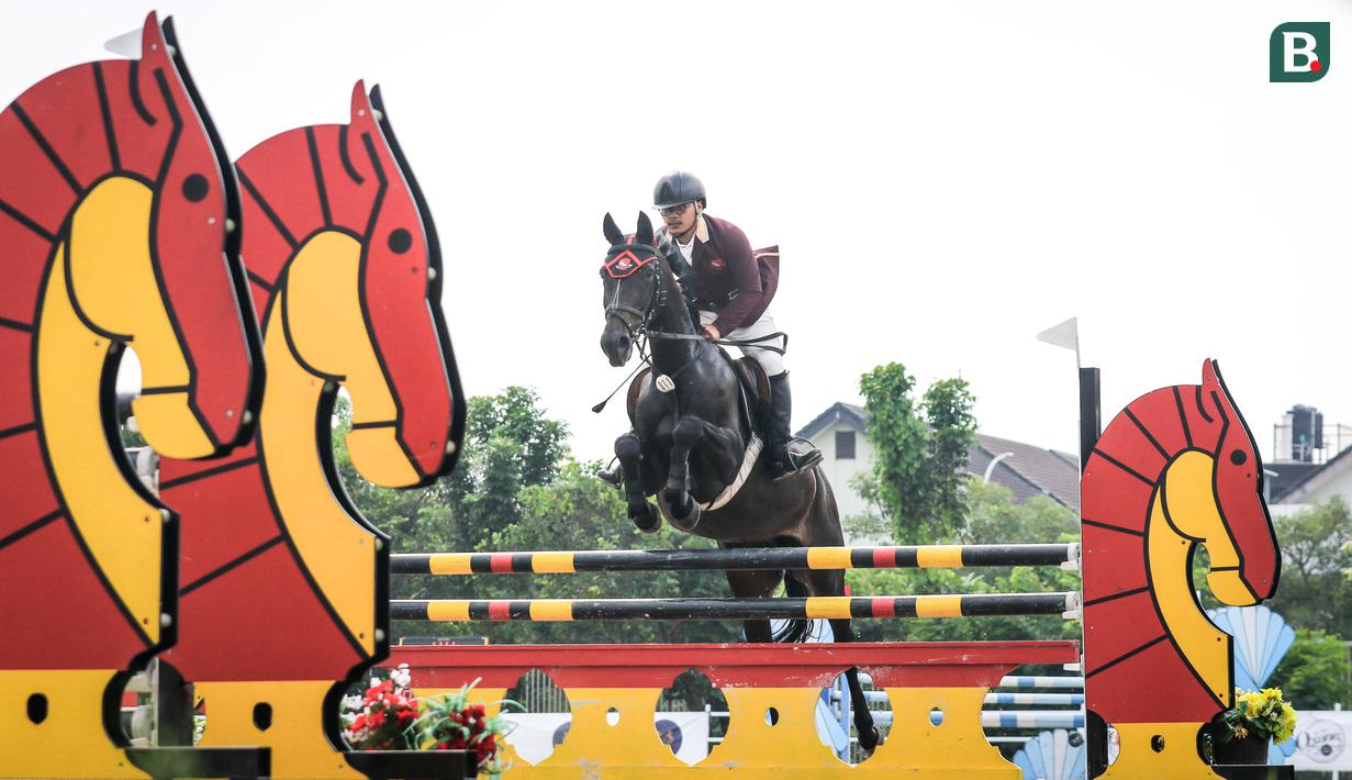 Atlet berkuda tim Almor Stable, Muhamad Zaki beraksi pada nomor Show Jumping 105 cm saat ajang Solidarity Equestrian Challange 2022 yang berlangsung di Jakarta International Equestrian Park, Jakarta Timur, Minggu (30/01/2022). (Bola.com/Bagaskara Lazuardi)